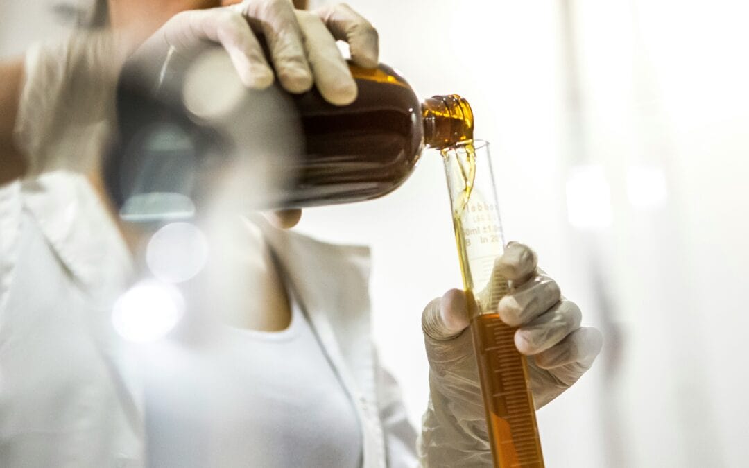 Chemikalien werden von einem Glasbehälter in eine Reagenzglas geschüttet