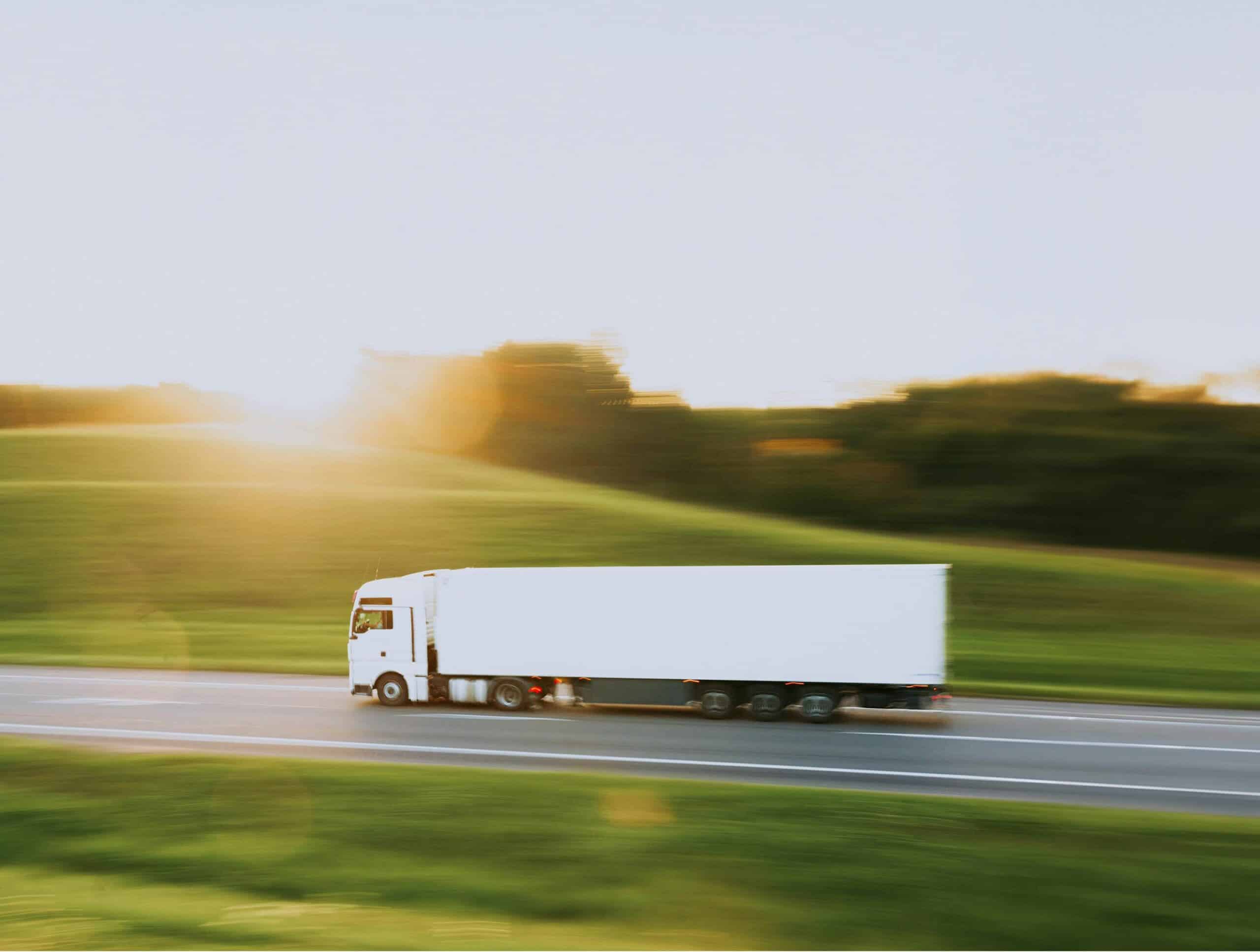 Ein LKW fährt schnell über eine einsame Straße